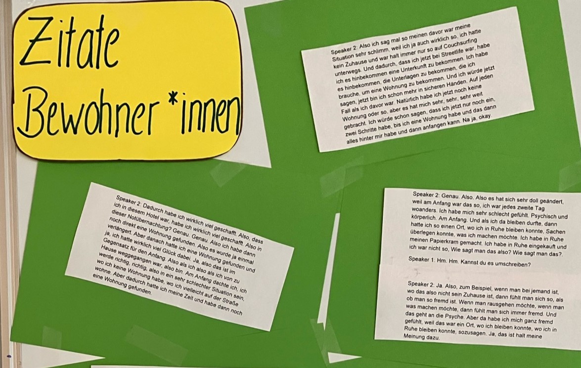 Ein gelbes und drei Grüne Plakate, auf denen Zitate von Bewohner*innen stehen.