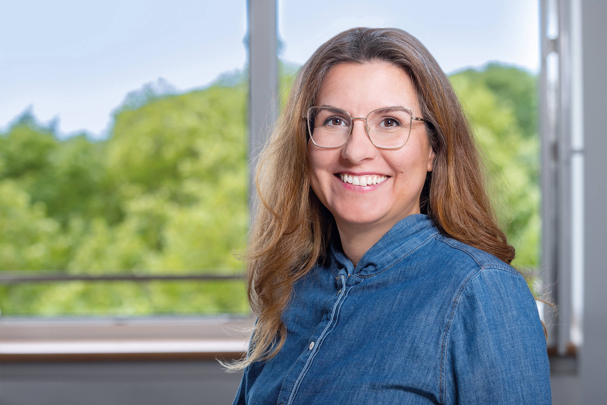 Eine Frau mit Brille lächelt in die Kamera (c) Annette Schrader Eine Frau mit Brille lächelt in die Kamera