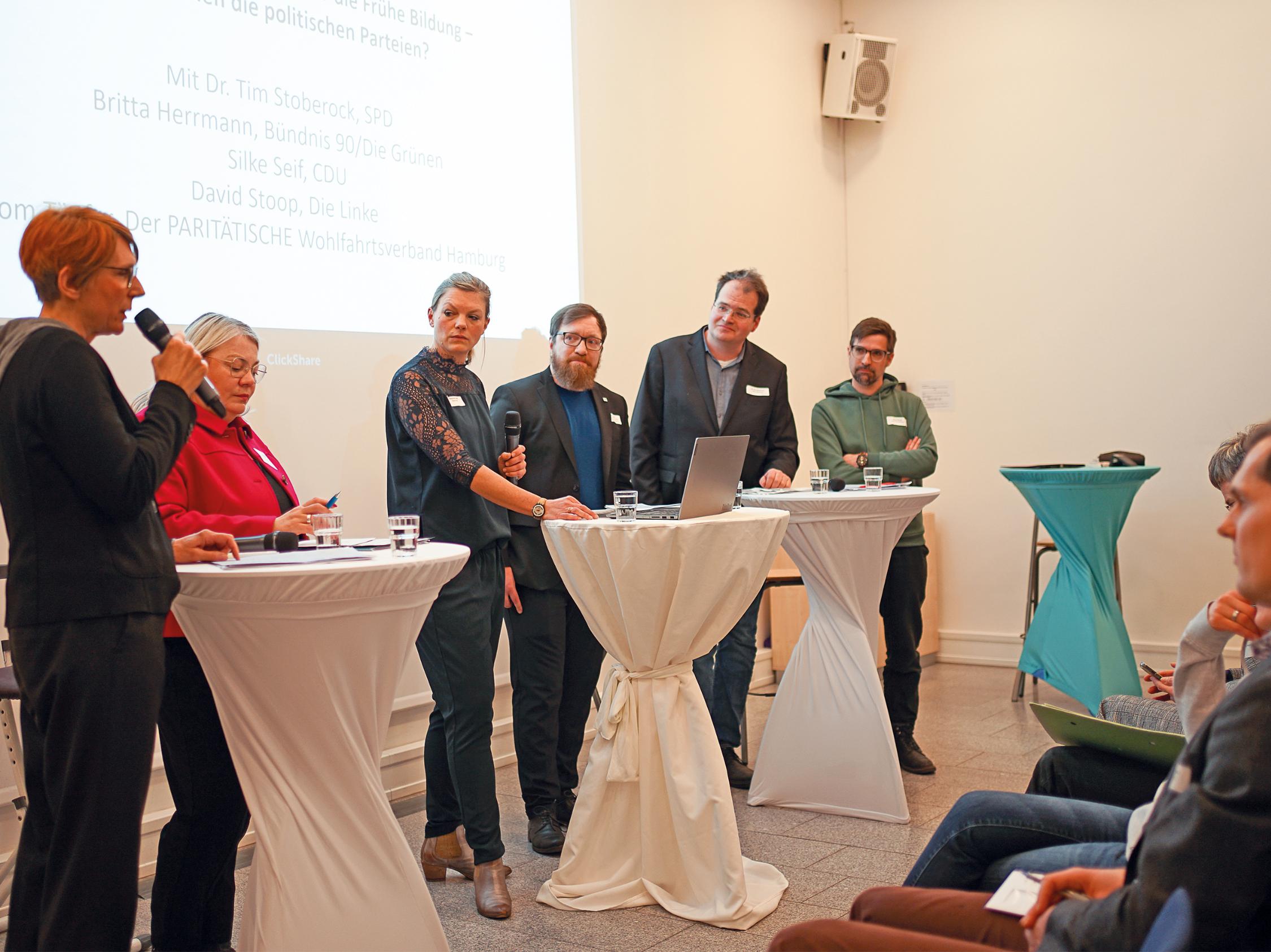 Politiker an weißen Stehtischen bei der Diskussion zum Kitagutschein